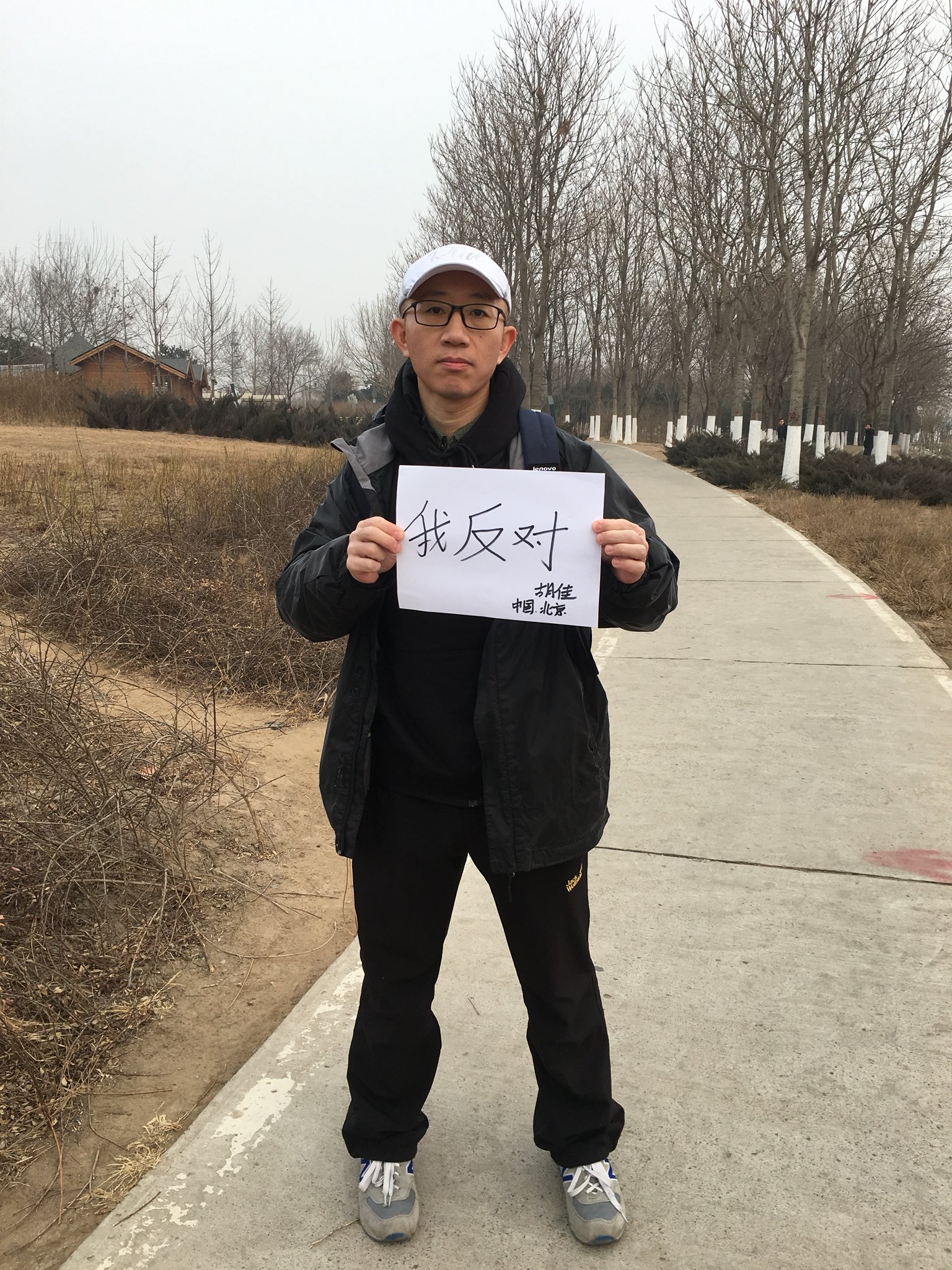 a photo of Hu Jia holding a baby, with her mother and mother-in-law on each side